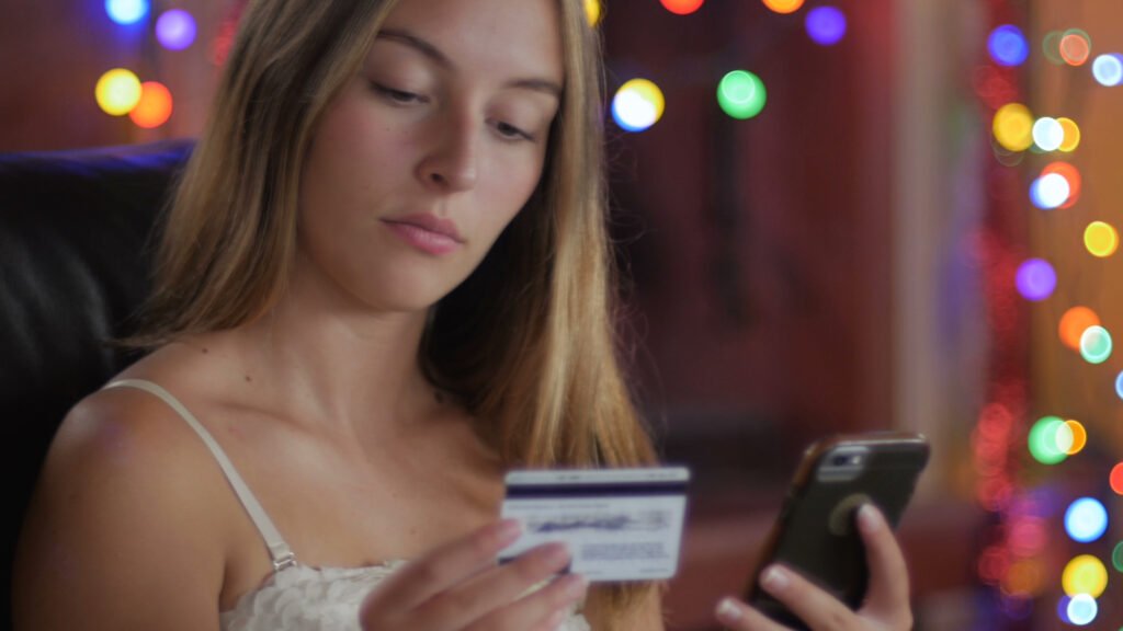 a-beautiful-young-woman-with-long-blond-hair-orders-from-her-smart-phone-with-her-credit-card