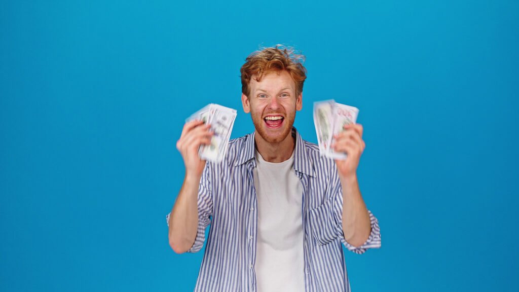 focused-redhead-man-counts-dollar-bills-after-getting-salary